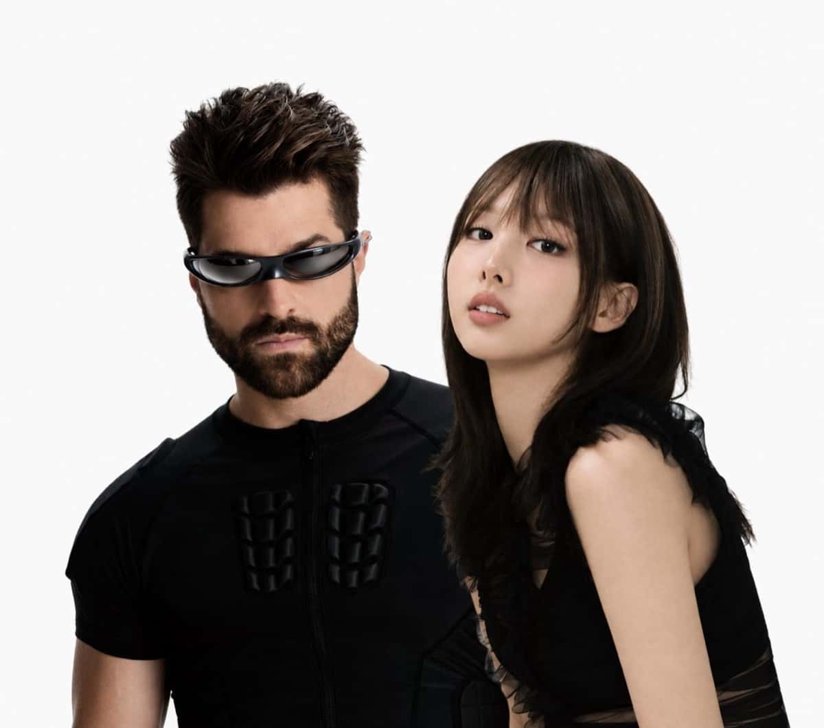 Foto oficial de prensa de Alok, con anteojos de sol negros envolventes y remera negra acolchada, junto a NAYEON de TWICE, de pelo largo castaño con flequillo y vestido negro con transparencias, sobre fondo blanco