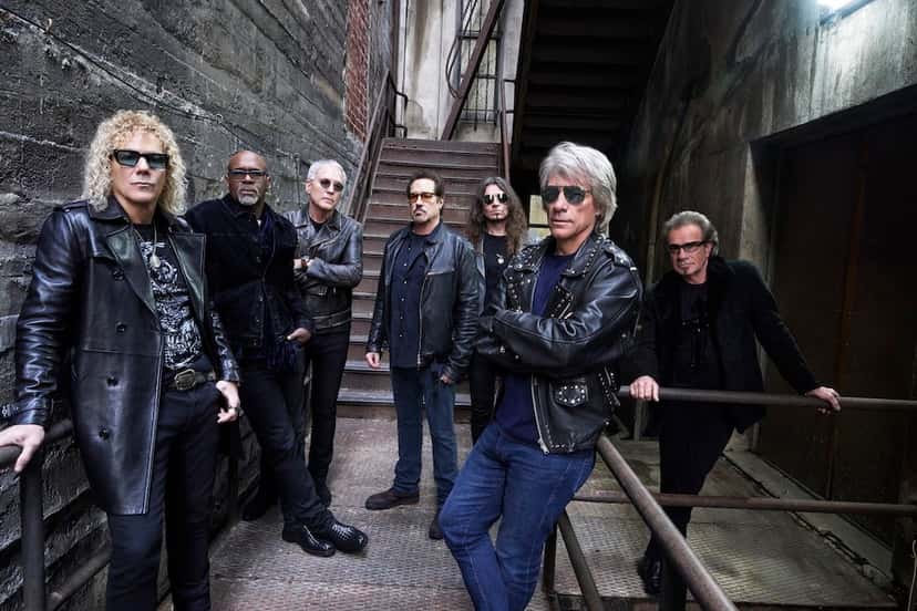 Foto de prensa de Bon Jovi por Mark Seliger: los siete integrantes, con camperas de cuero negras y anteojos de sol, posan en un pasillo de paredes de ladrillo gastado al pie de una escalera de metal; Jon Bon Jovi, de pelo canoso, está adelante a la derecha