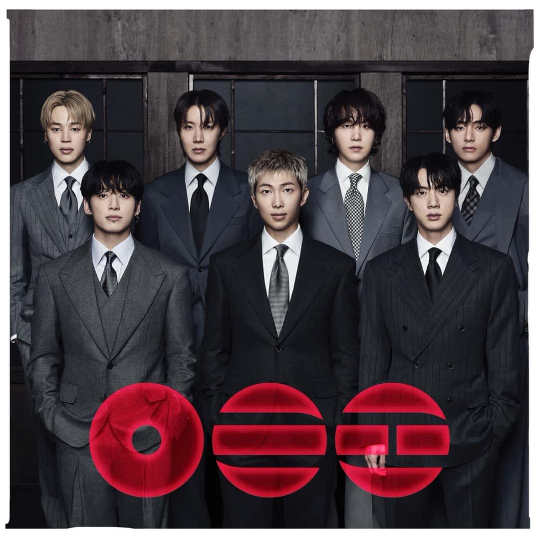 Portada de «ARIRANG», de BTS: los siete integrantes de traje gris frente a una pared de madera oscura, con el título en letras coreanas rojas en primer plano