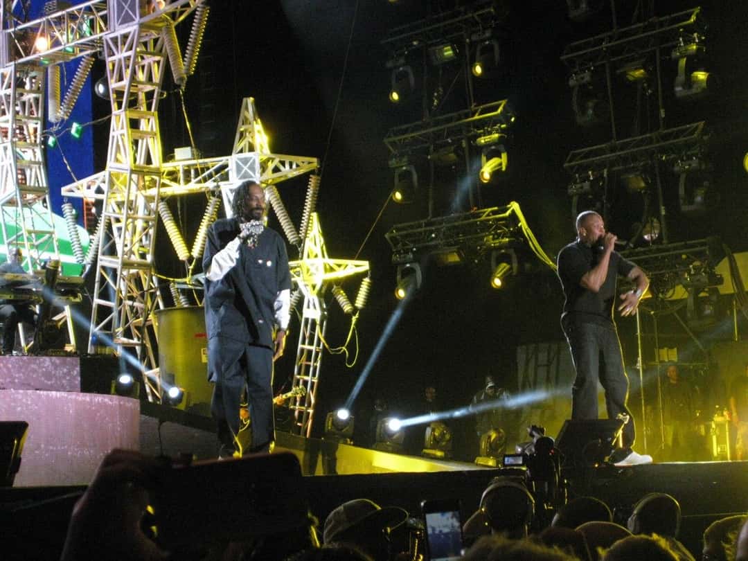 Snoop Dogg y Dr. Dre en el escenario del festival Coachella en 2012, bajo torres de luces amarillas (foto de archivo). Foto: David Hwang, CC BY 2.0, vía Wikimedia Commons