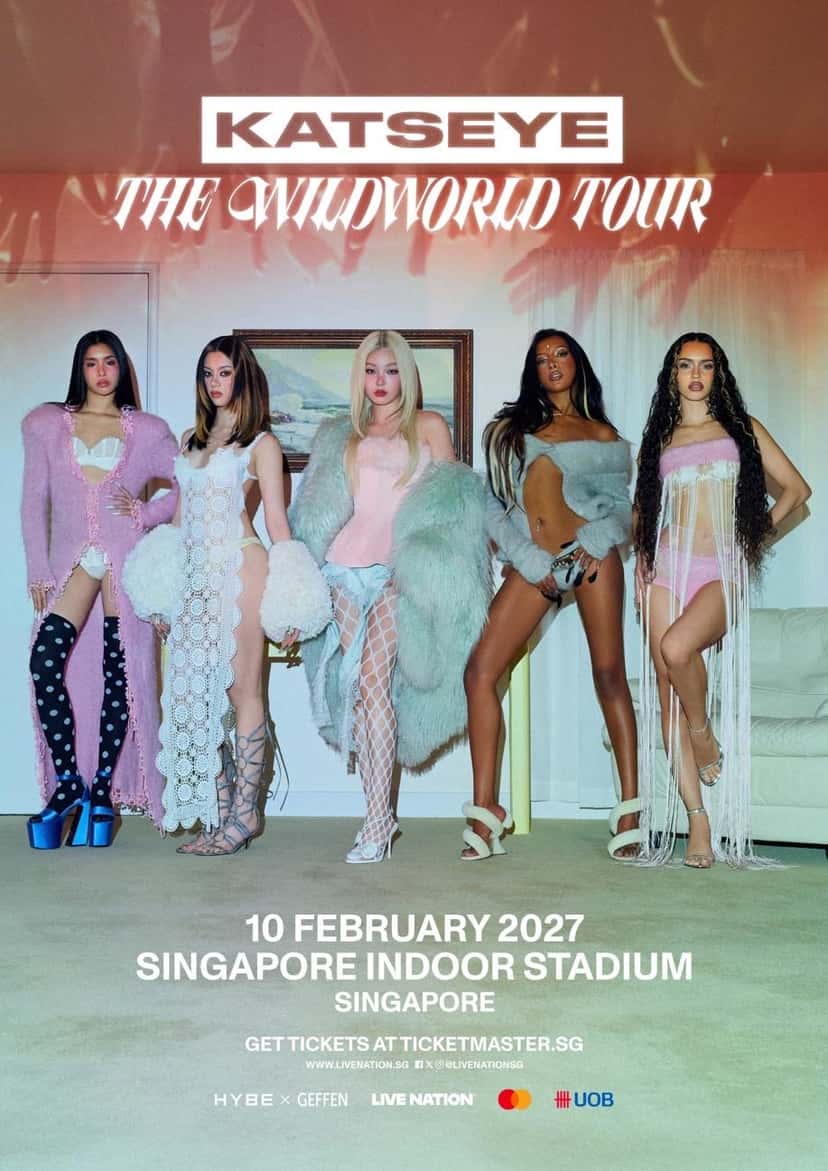 Afiche oficial de «The Wildworld Tour» para Singapur: cinco integrantes de KATSEYE de pie en un living, con ropa clara de piel, encaje y botas, debajo del logo del grupo y del título de la gira, con la fecha del 10 de febrero de 2027 en el Singapore Indoor Stadium. Imagen: HYBE x Geffen / Live Nation