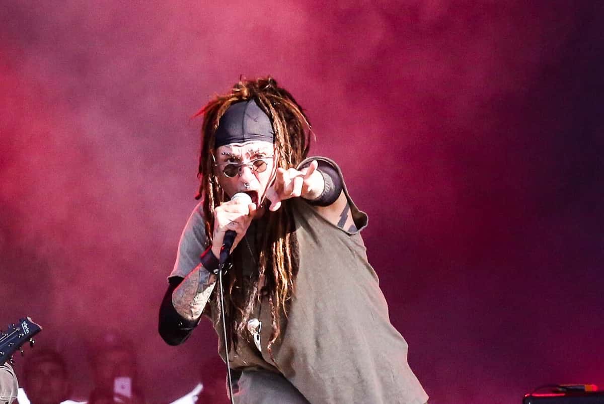 Al Jourgensen, con rastas largas, pañuelo en la cabeza y anteojos oscuros, canta y señala al público en el escenario del festival Hellfest, entre humo rojo (foto de archivo, junio de 2017)