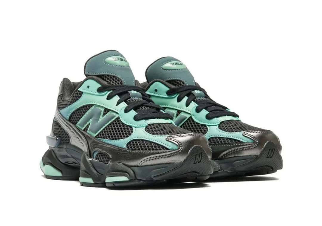 New Balance 9060 Deep End/Black Metallic vista de tres cuartos, con la malla negra, los refuerzos metalizados y los detalles verde agua