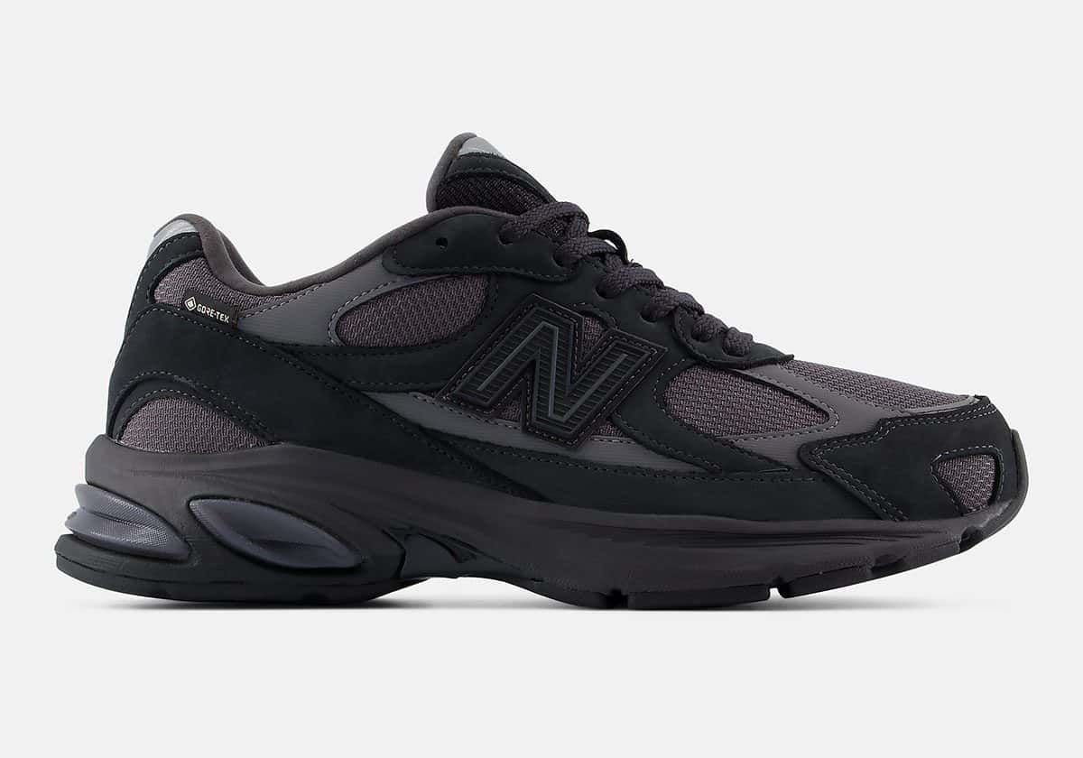 New Balance 2010 GORE-TEX Black/Field Green de perfil, con malla gris oscura, refuerzos de cuero negro, N negra y suela negra, sobre fondo gris claro
