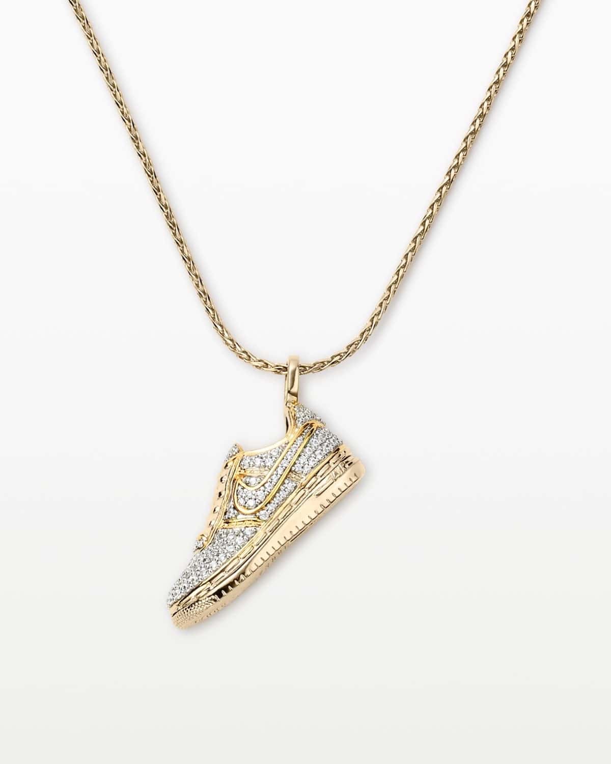 Collar Nike Air Force 1 sobre fondo blanco, con un dije dorado en forma de Air Force 1 Low cubierto de pequeñas piedras transparentes, el Swoosh y la suela marcados en dorado y una cadena trenzada dorada