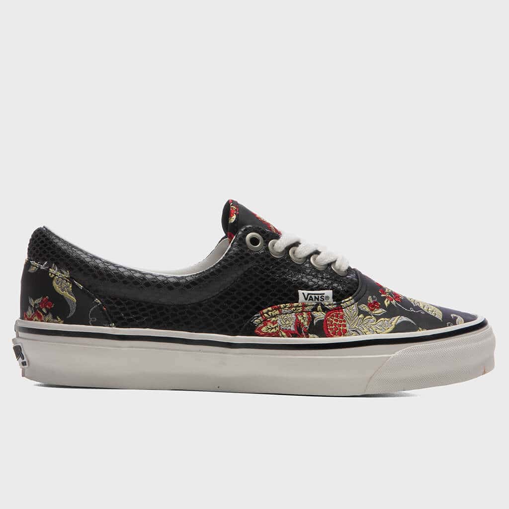 OTW by Vans Era 95 Vibram Floral Black de perfil sobre fondo gris claro, con paneles negros de textura tipo red, textil negro con flores rojas y doradas en la puntera y el talón, ojales metálicos, cordones crudos y suela blanca con línea negra