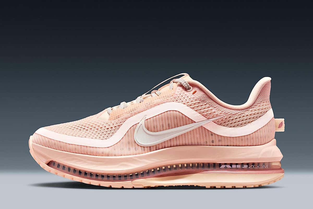 Nike Pegasus Premium Guava Ice de perfil, con malla color durazno, Swoosh blanco, refuerzos translúcidos y la unidad Air Zoom visible en la entresuela, sobre fondo gris azulado