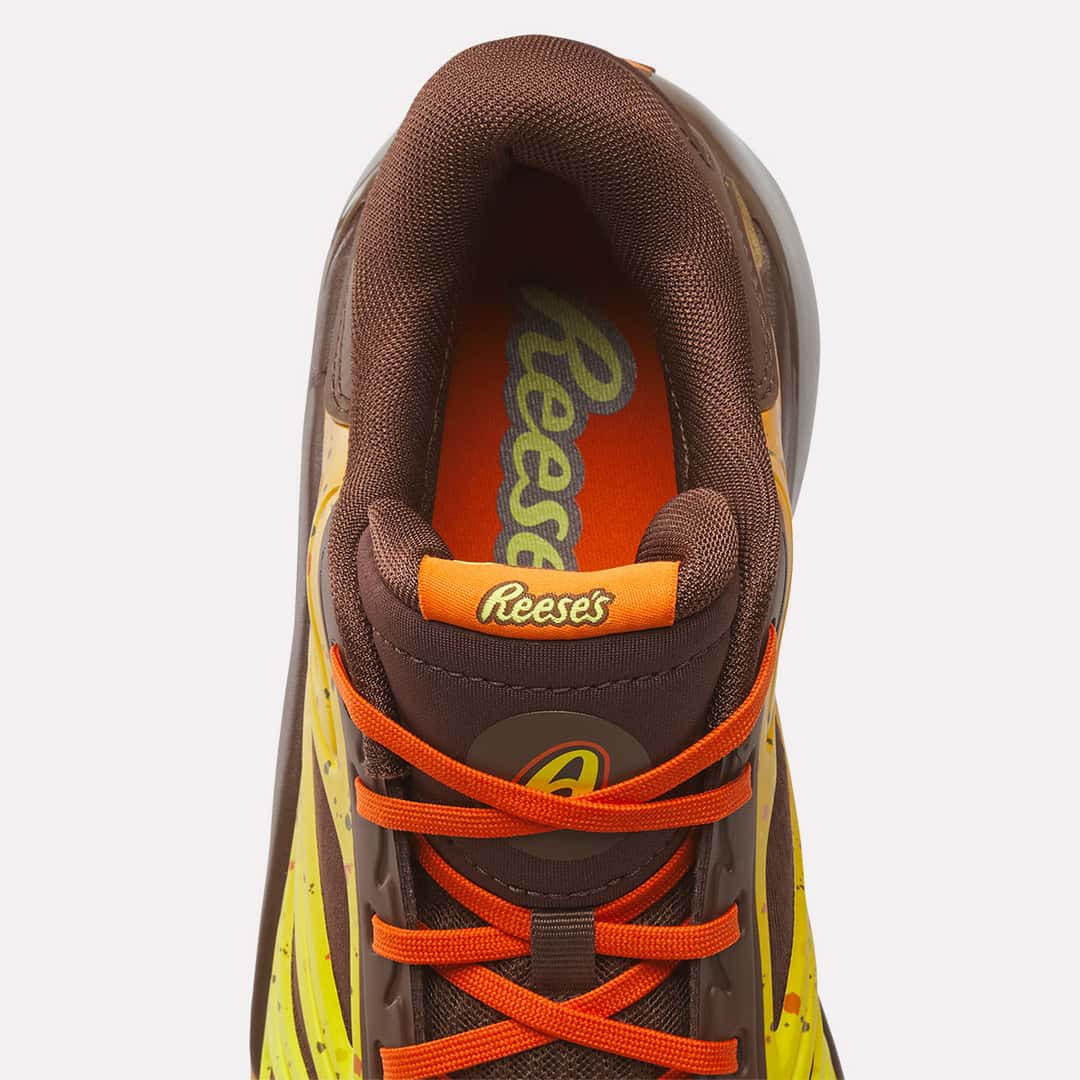 Detalle de la Reebok Angel Reese 1 Reese's con logo de Reese's en la lengüeta y en la plantilla naranja, y el monograma AR al frente