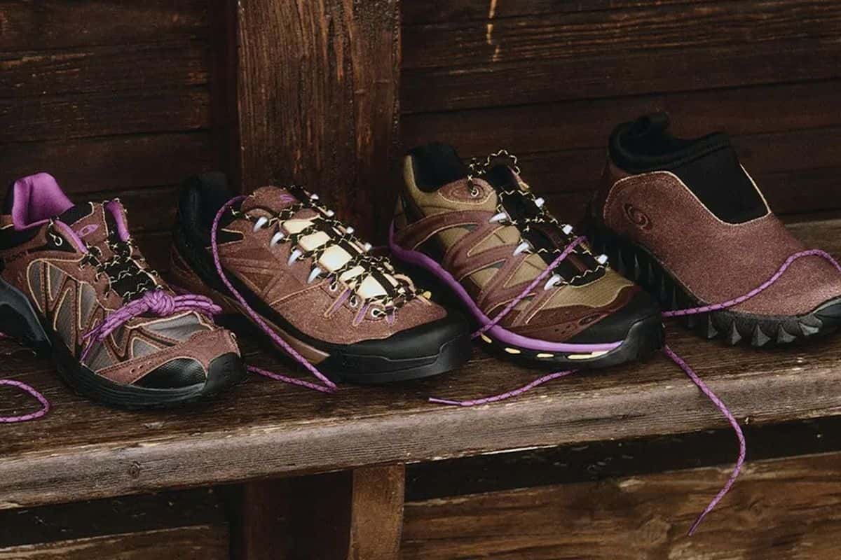 Los cuatro modelos del Salomon Expedition Pack en marrón, apoyados sobre un banco de madera con cordones violetas