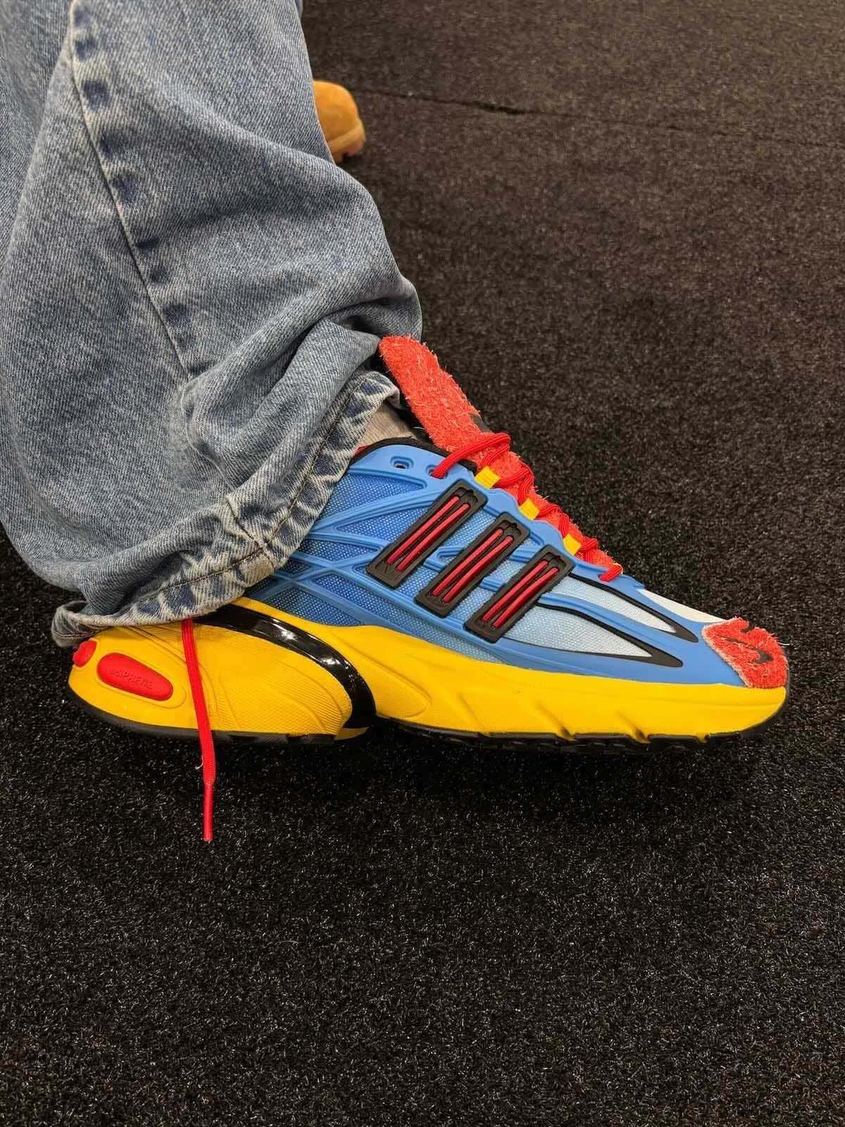 adidas Adistar XLG 2.0 Mandrill de Shake James puesta, con malla azul en degradé, tres tiras negras con detalle rojo, gamuza peluda roja y mediasuela amarilla