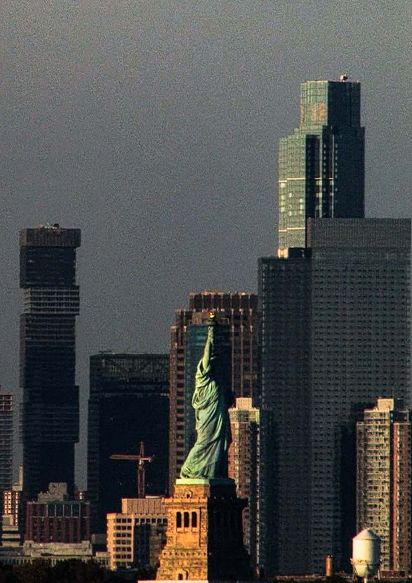 La Estatua de la Libertad con edificios altos detrás y el cielo gris. Foto: Sébastien Lorsbach y Julien Caldarone para Salomon