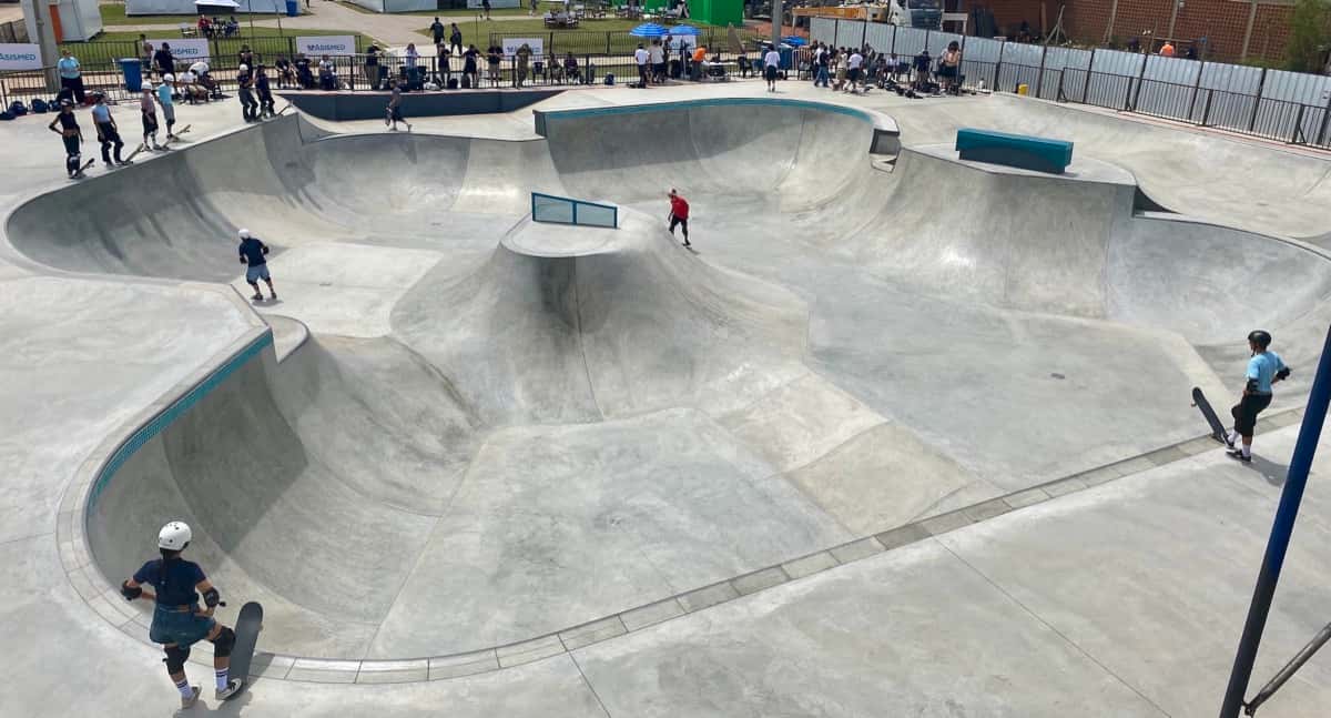 Vista desde arriba del bowl de concreto del Parque Olímpico de Luque, con skaters con casco entrenando sobre los bordes y en el fondo de la pista