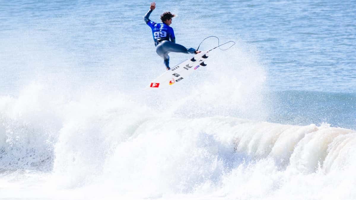 Foto de archivo: Griffin Colapinto, con la lycra azul, vuela sobre la espuma de una ola en Supertubos con la tabla en el aire, en la segunda ronda del MEO Rip Curl Pro Portugal