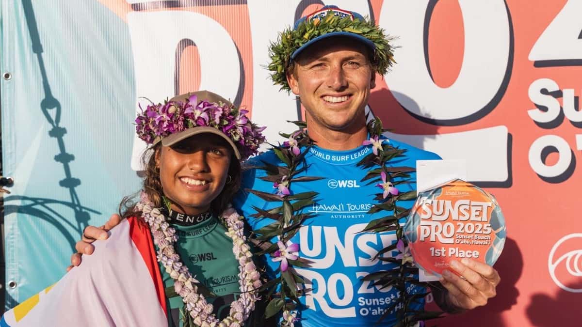 Kiara Goold y Finn McGill, con coronas de flores y collares, posan con el trofeo de campeones del HTA Sunset Pro 2025 (foto de archivo)