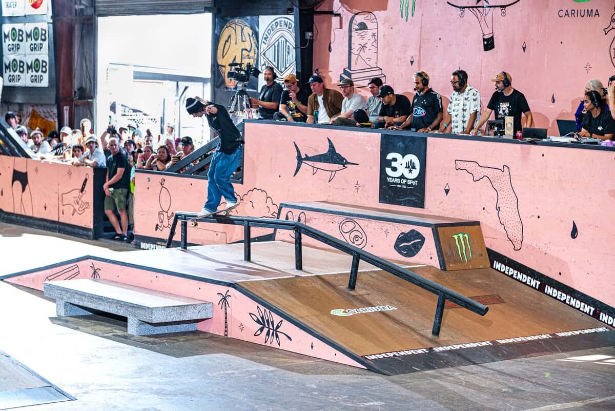 Foto de archivo: un skater hace un grind sobre la baranda de la pista de street del Tampa Am, con público y la mesa de jueces de fondo