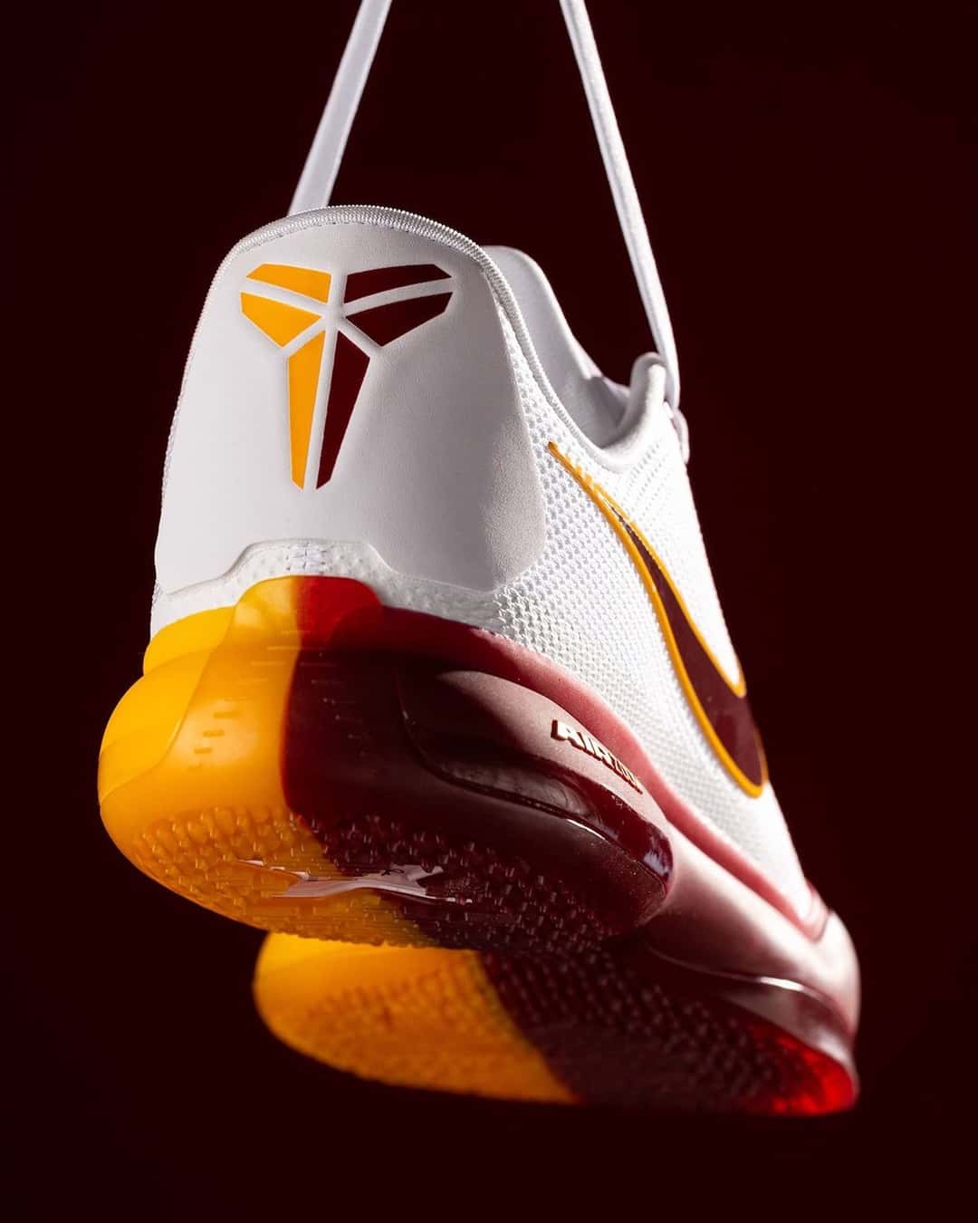 Talón de la Nike Kobe 10 Protro blanca de USC, con el logo de Kobe en dorado y la media suela amarilla y bordó