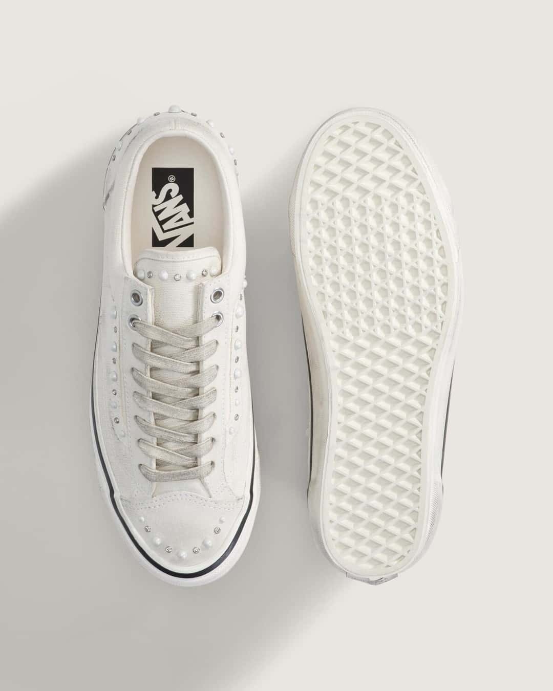 Vista superior del Vans Old Skool 36 Pearlized Marshmallow White junto a la suela waffle, con la plantilla de logo Vans y las perlas sobre la puntera de gamuza