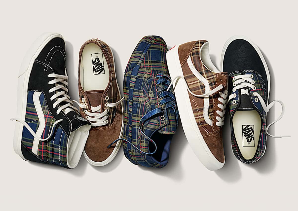 Cinco zapatillas de la colección Vans Plaid alineadas sobre fondo crema: un Sk8-Hi de gamuza negra con cuadros azules, un Authentic de gamuza marrón con cuadros marrones, un Premium Old Skool cubierto de cuadros azules con cordones azules, un Old Skool marrón con Sidestripe crema y un Authentic de punta negra con cuadros azules
